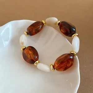 Retro-Armband aus Acrylperlen in Bernstein und Weiß mit eleganten goldenen Details