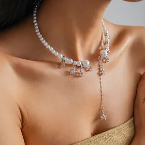 Detail view of elegant pearl choker necklace with silver star pendants and long tassel drop.