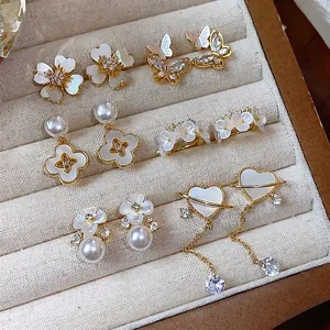 Élégant ensemble de boucles d'oreilles fleurs et papillons plaqué or 14 carats et zircons.