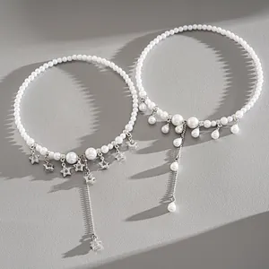 Detail view of pearl tassel chokers with star and teardrop charms in silver finish.