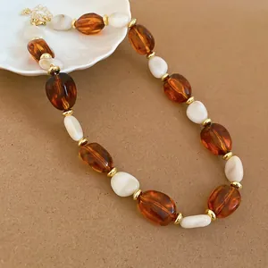 Retro elegant necklace featuring amber and white acrylic oval beads with golden spacers