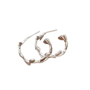 Boucles d'oreilles créoles feuilles en argent au design minimaliste branche d'olivier.