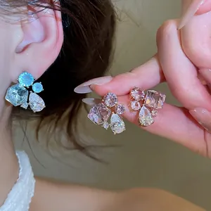 Elegant sparkling zircon geometric teardrop stud earrings on model's ear and hand.