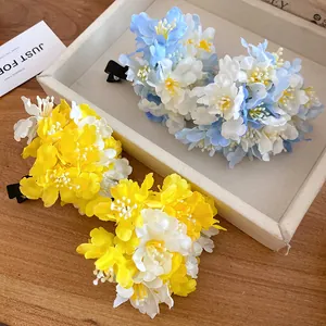 Close-up of sweet fabric flower hair clips in yellow and blue holiday style
