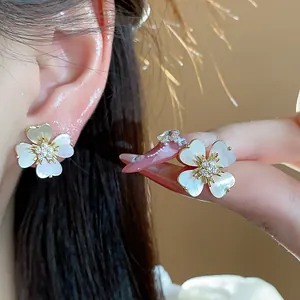 Vue détaillée des boucles d'oreilles fleurs plaquées or 14 carats avec pétales nacrés