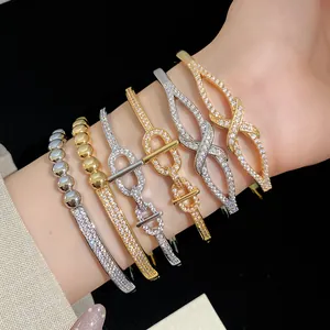 Gros plan d'élégants bracelets en zircon plaqués or 18 carats et argent sur un poignet