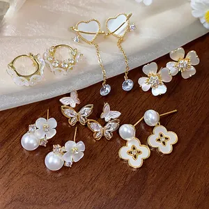 Collection de boucles d'oreilles plaquées or 14k avec fleurs et papillons élégants.