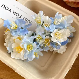 Close-up of sweet blue and white fabric flower hair clips in a rustic tray