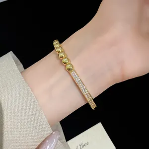 Gros plan d'un bracelet en zircon plaqué or 18 carats avec perles élégantes au poignet
