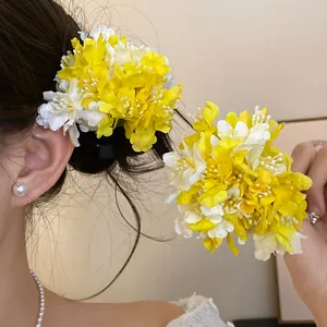 Close-up detail of yellow and white fabric flower hair clip styled on hair for vacation look