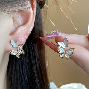 Détail de boucles d'oreilles papillon élégantes plaquées or 14 carats avec zircone