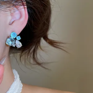 Close-up view of sparkling zircon geometric teardrop stud earrings worn on ear for detail