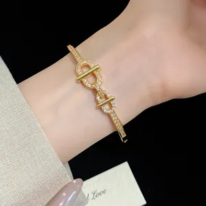 Détail d'un bracelet jonc luxueux en plaqué or 18 carats avec zircons sur un poignet