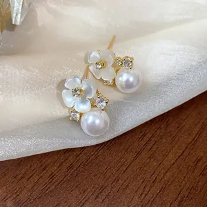 Vue détaillée des boucles d'oreilles fleurs plaquées or 14k avec perles et zircons