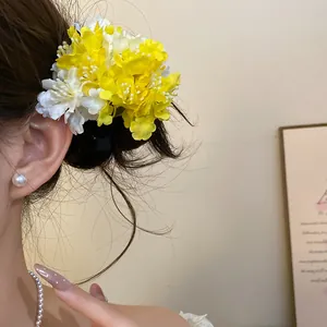 Detailed side view of sweet yellow and white fabric floral hair clip worn on casual hairstyle