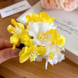 Close-up of sweet yellow and white fabric flower hair clip accessory for elegant styling