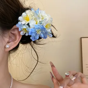 Close-up view of elegant blue and white fabric flower hair clip worn on a bun hairstyle