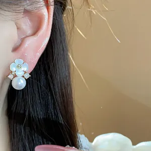 Vue détaillée d'une boucle d'oreille fleur plaquée or 14k avec perle et oxydes de zirconium