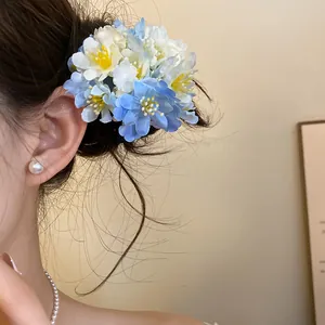 Close-up detail of a blue and white fabric flower hair clip styled on an elegant hair bun