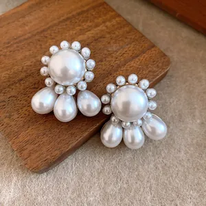 Close-up of French vintage style stud earrings with round and teardrop shaped pearls