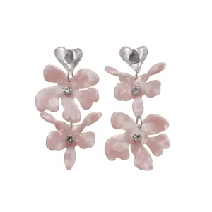 Eleganti orecchini a fiore in resina rosa con perni a cuore e molti cristalli.
