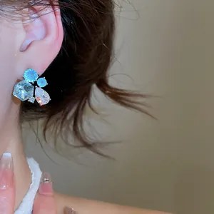 Detail view of elegant geometric teardrop earrings with sparkling blue zircons.