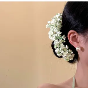 Detailed close-up of an elegant green floral hair pin on a classic Hanfu updo hairstyle