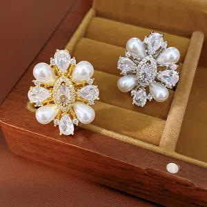 Primo piano di anelli vintage placcati oro 14k con perle e zirconi scintillanti