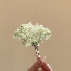 Detailed view of the delicate green and pink floral petals on a silver U-shaped hair pin