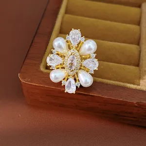 Dettaglio di un anello placcato oro 14k stile vintage con perle e zirconi chiari.