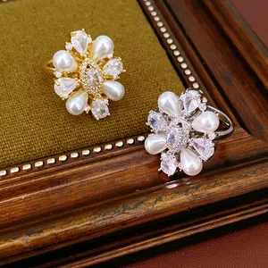 Vista dettagliata di anelli a fiore vintage con perle e zirconi in oro e argento