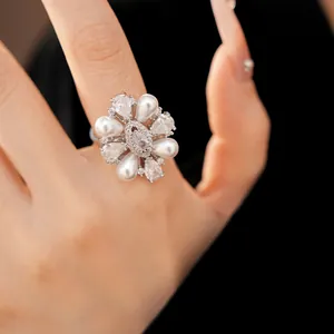 Primo piano macro di un anello a fiore di lusso con perle e pietre di zircone