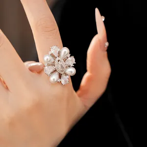 Primo piano dettagliato di un anello a fiore stile reale con perle e pietre di zircone