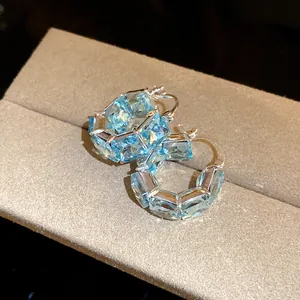 Macro di eleganti orecchini a cerchio vintage con zirconi blu chiaro a taglio quadrato