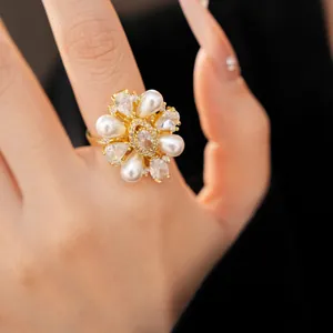 Dettaglio di un anello a fiore placcato oro 14k con zirconi e perle molto eleganti