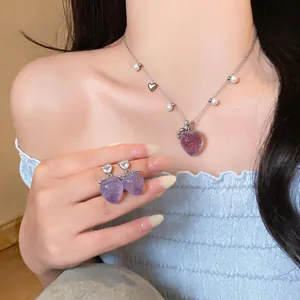 Primo piano dell'elegante collana fragola viola e orecchini di zirconi abbinati