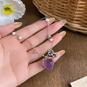 Vista dettagliata della collana con ciondolo a fragola viola, perle e sfere d'argento