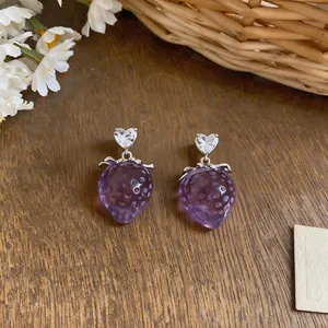 Dettaglio delle orecchini a fragola viola con zirconi a forma di cuore su base in argento
