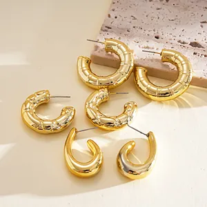 Macro view of a six-piece set featuring gold geometric C-shaped and teardrop earrings