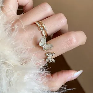 Elegante set di anelli a farfalla placcati oro 14k con zirconi sulla mano della modella