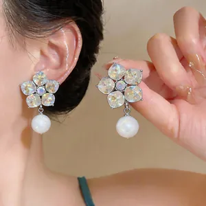 Detailed view of elegant flower-shaped earrings with iridescent stones and pearl drops