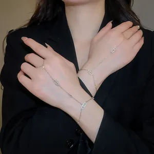 Sparkling zircon oval hand chain bracelet in gold finish worn on hand