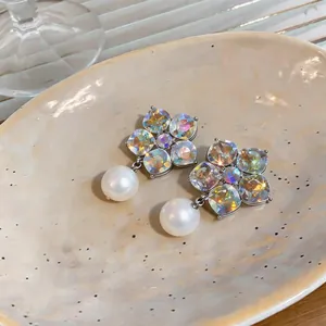 Detailed view of silver flower stud earrings with iridescent crystals and pearls