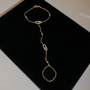 Detailed macro view of a gold-tone slave bracelet with sparkling zircon ovals.