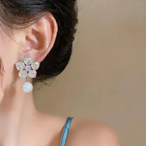 Elegant French style floral crystal stud earrings with a pearl drop shown on model's ear
