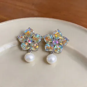 Close-up of elegant flower-shaped earrings with colorful crystals and pearls.