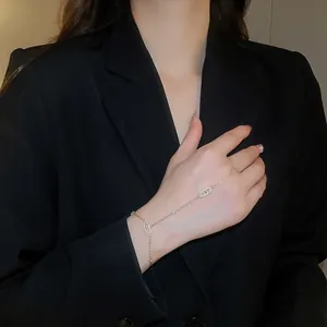 Elegant gold hand harness bracelet featuring zircon-encrusted oval links on a model's hand