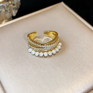 Vista dettagliata di un anello placcato oro 14k con zirconi e file di perle