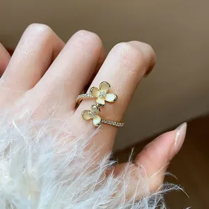 Primo piano di un anello placcato oro 14k con petali di fiori in zircone sulla mano
