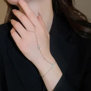 Close-up of elegant silver hand chain with sparkling zircon oval links on a model.